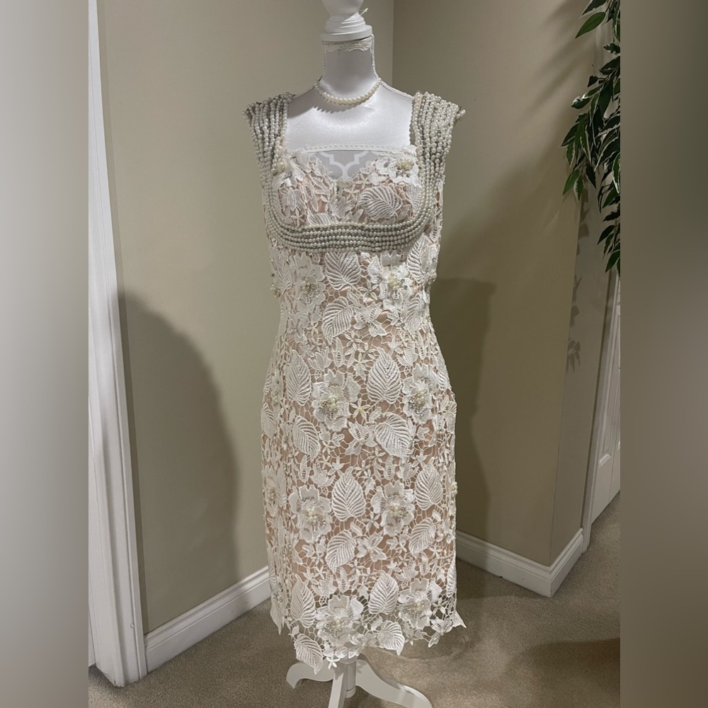 Elegant cocktail dress with a beautiful pearl and a stone detail.